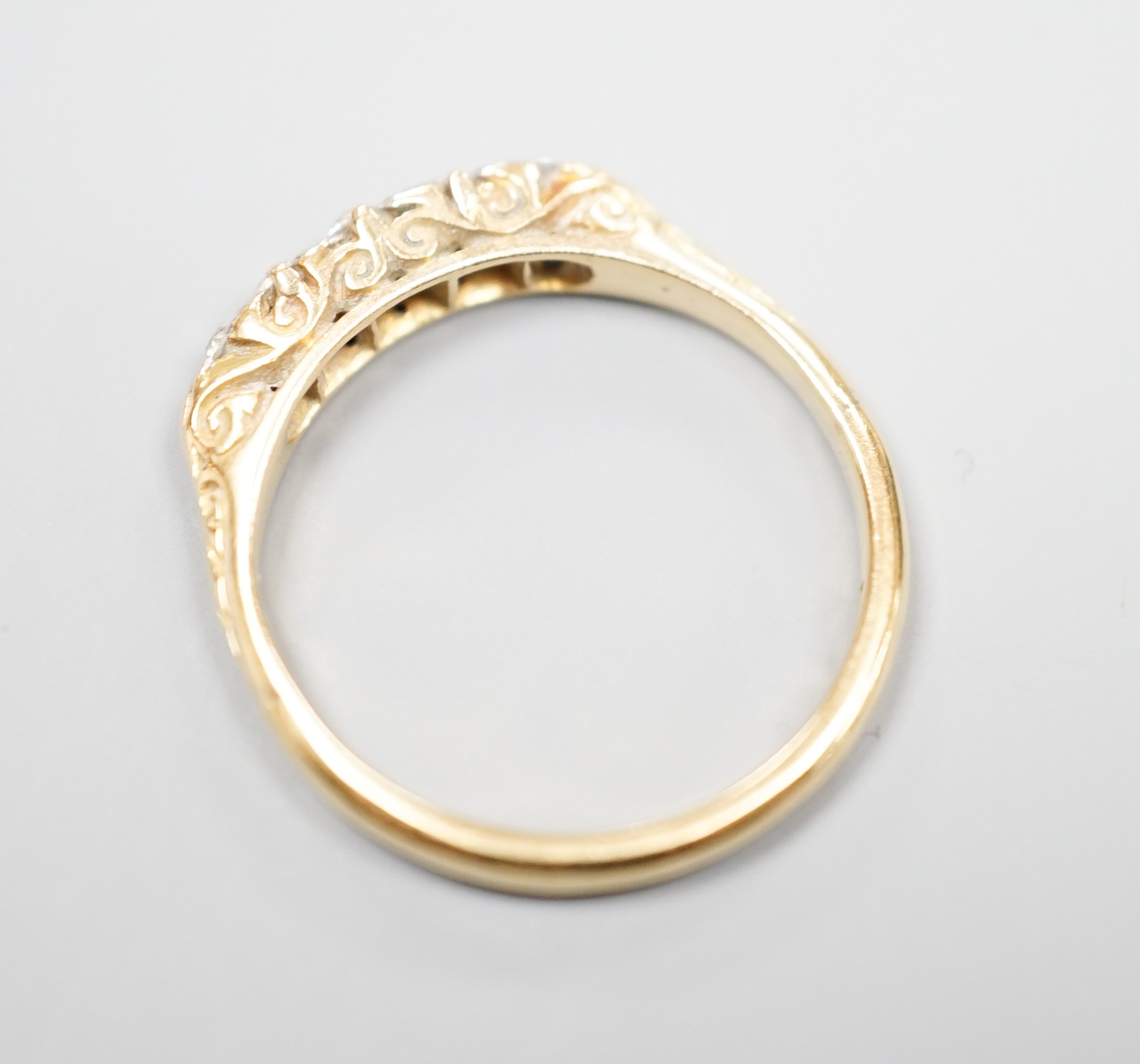 An 18ct and graduated five stone diamond set half hoop ring, size O, gross weight 3 grams.